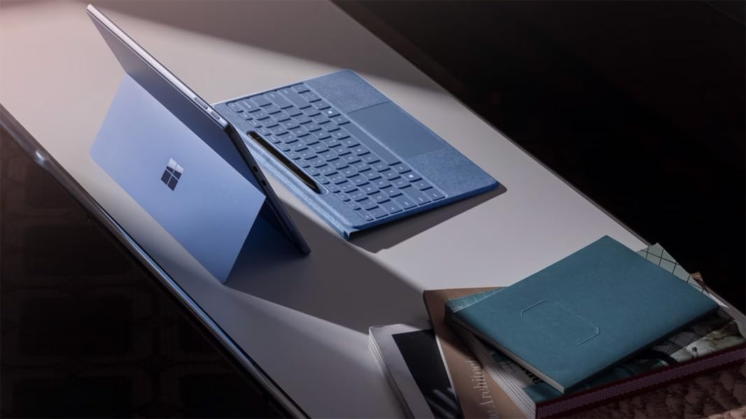 Microsoft Type Cover beside Surface Pro for scale, demonstrates slim lightweight design