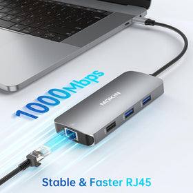 MOKiN hub next to MacBook to show scale and portable convenience