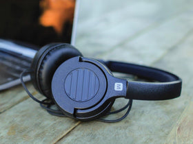 Monoprice on-ear headphones shown beside a travel bag, portable.