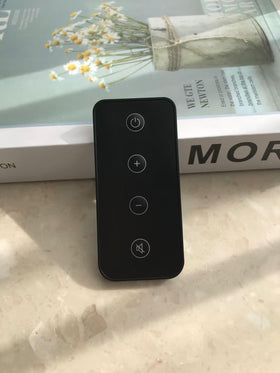 MONSIATUG remote held in hand to show compact size and ergonomic benefit