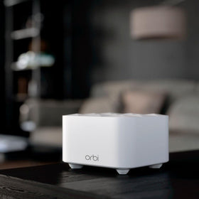 NETGEAR Orbi RBK13 next to common objects showing size and discreet home placement benefit