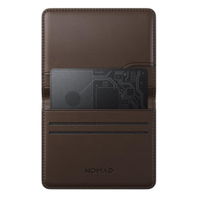 NOMAD tracking card beside passport and luggage tag showing travel-ready durability