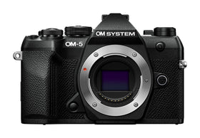 OM SYSTEM OM-5 Mark II body in rugged wilderness, ready for travel photography.