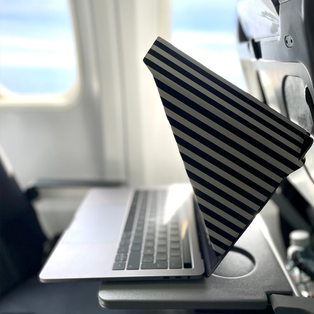 Philbert on a beach laptop blocking sun and lowering screen heat benefit
