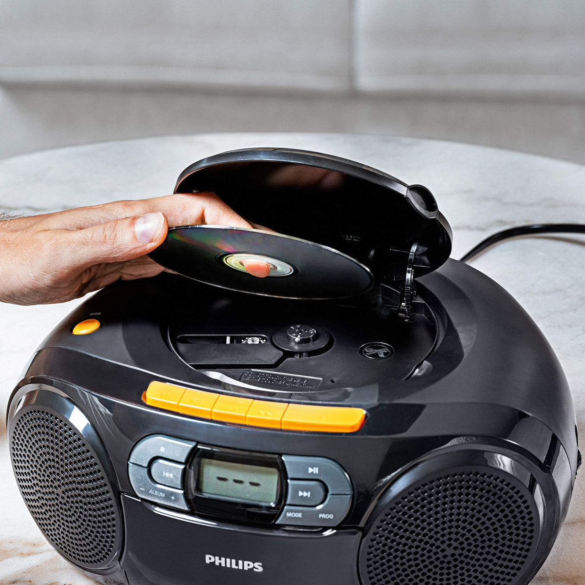 PHILIPS travel-ready boombox shown outdoors for on-the-go listening.