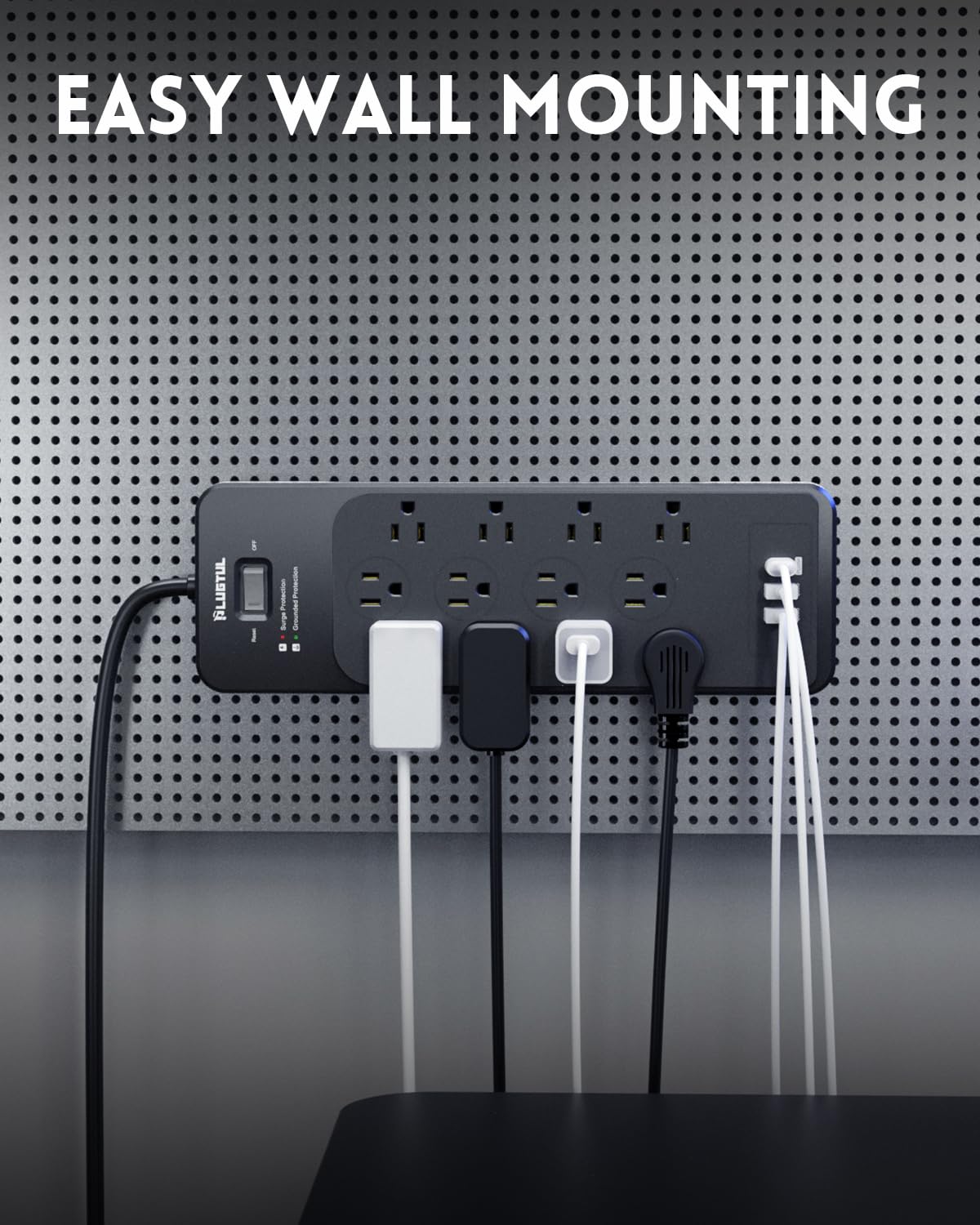 PLUGTUL on a home desk powering monitors, laptop, and phone charging