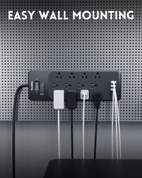 PLUGTUL on a home desk powering monitors, laptop, and phone charging