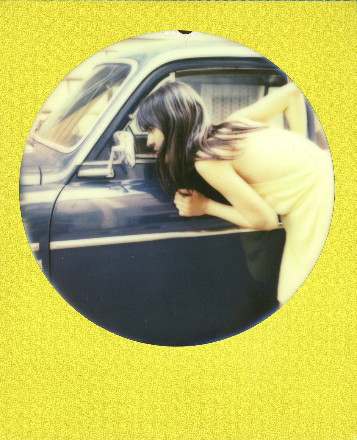 Polaroid 600 OneStep on tabletop with prints showing instant photo enjoyment
