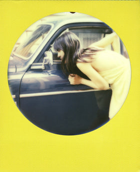 Polaroid 600 OneStep on tabletop with prints showing instant photo enjoyment