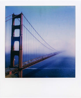 Hands holding fresh Polaroid prints from the Lab