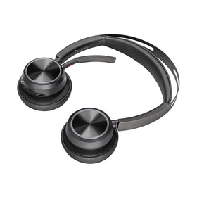 POLY Voyager Focus 2 headset beside charging stand for easy daily recharges