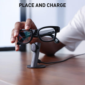 PRISMXR stand on a nightstand beside glasses for ready-to-wear convenience