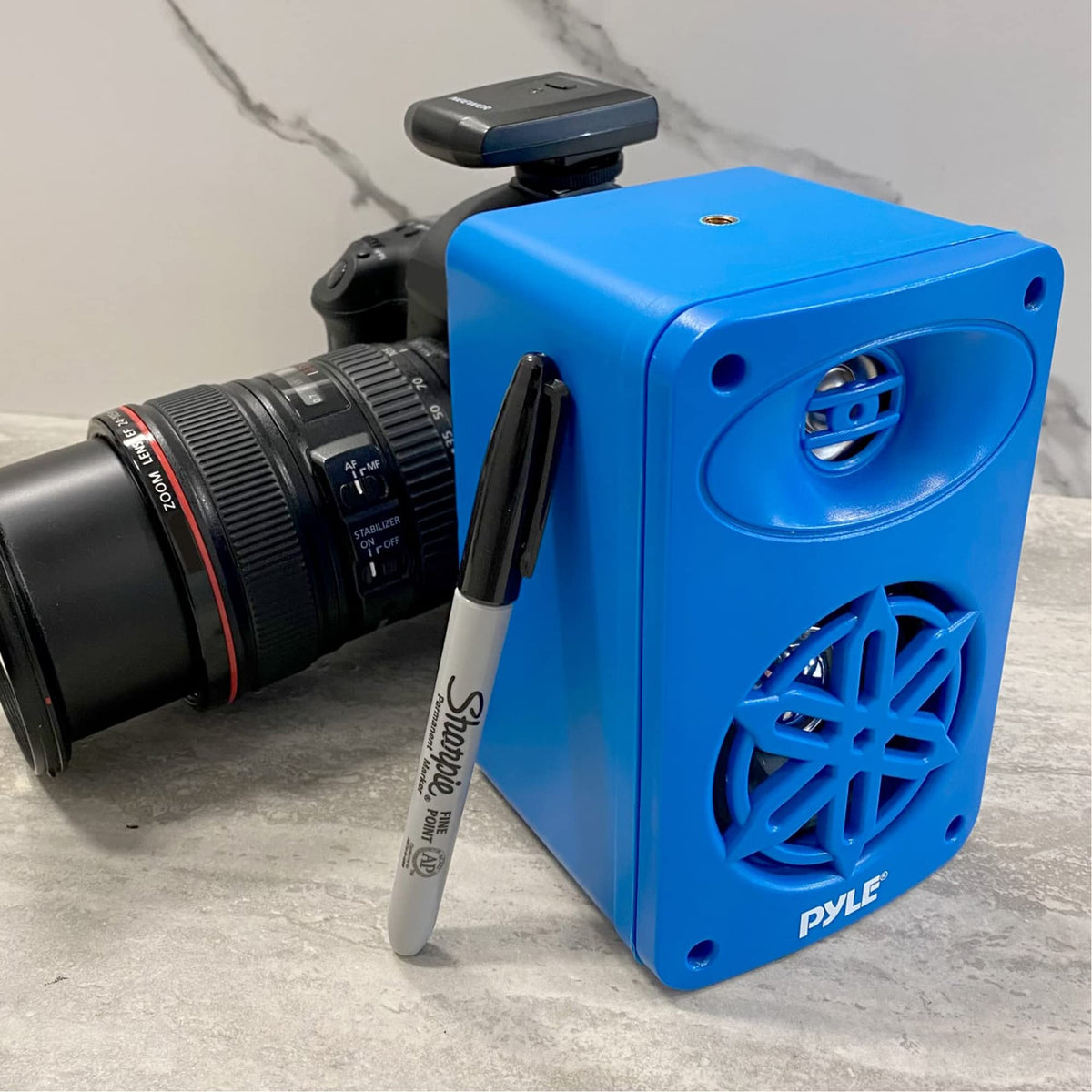 Pyle speaker next to a soda can for scale showing compact size and discreet fit