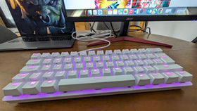 Razer Huntsman Mini beside mouse and phone showing portable 60% size advantage