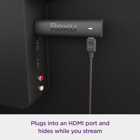 Roku stick tucked behind TV demonstrating discreet placement and clutter reduction