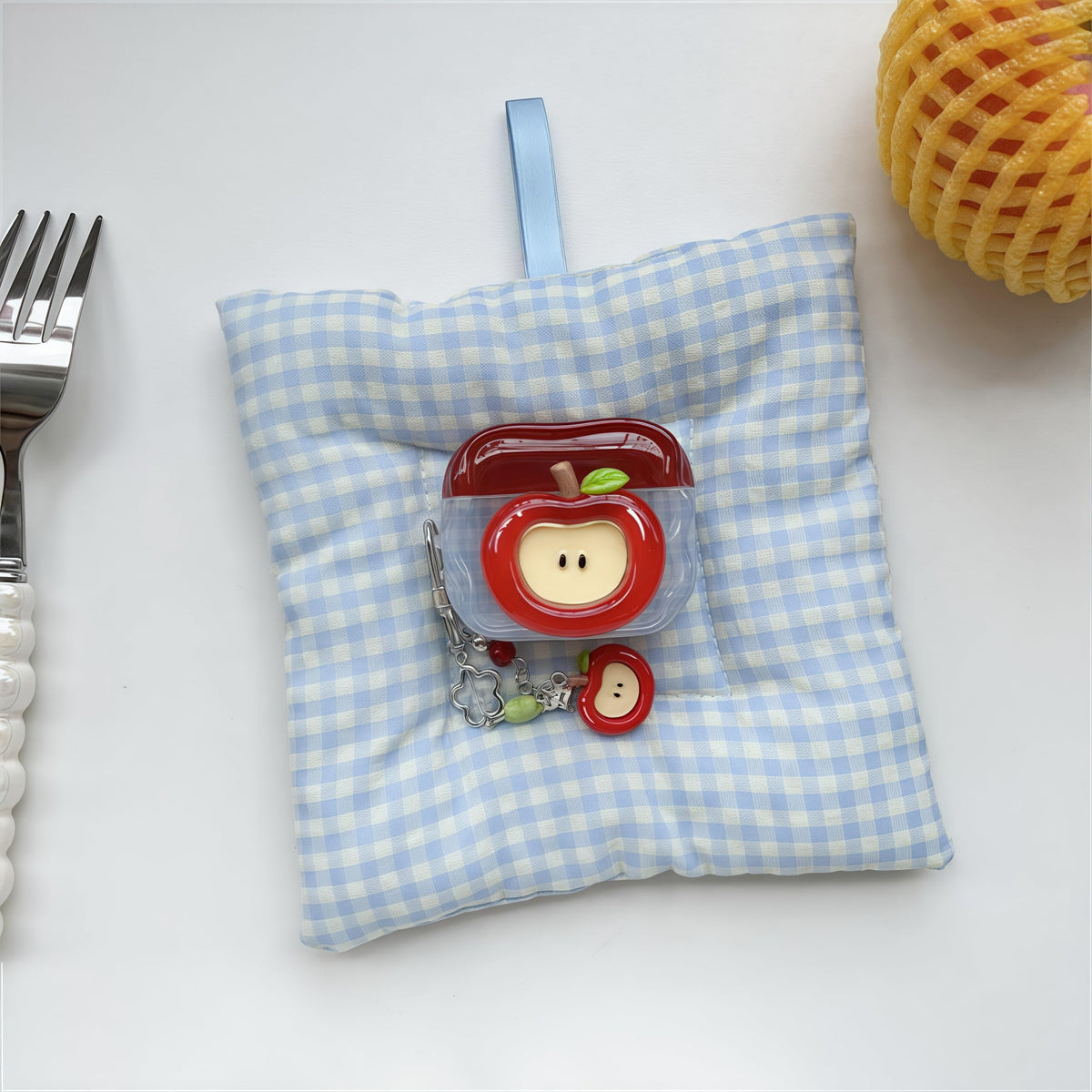 SGVAHY AirPods 4 case on a bag shows playful red apple design.