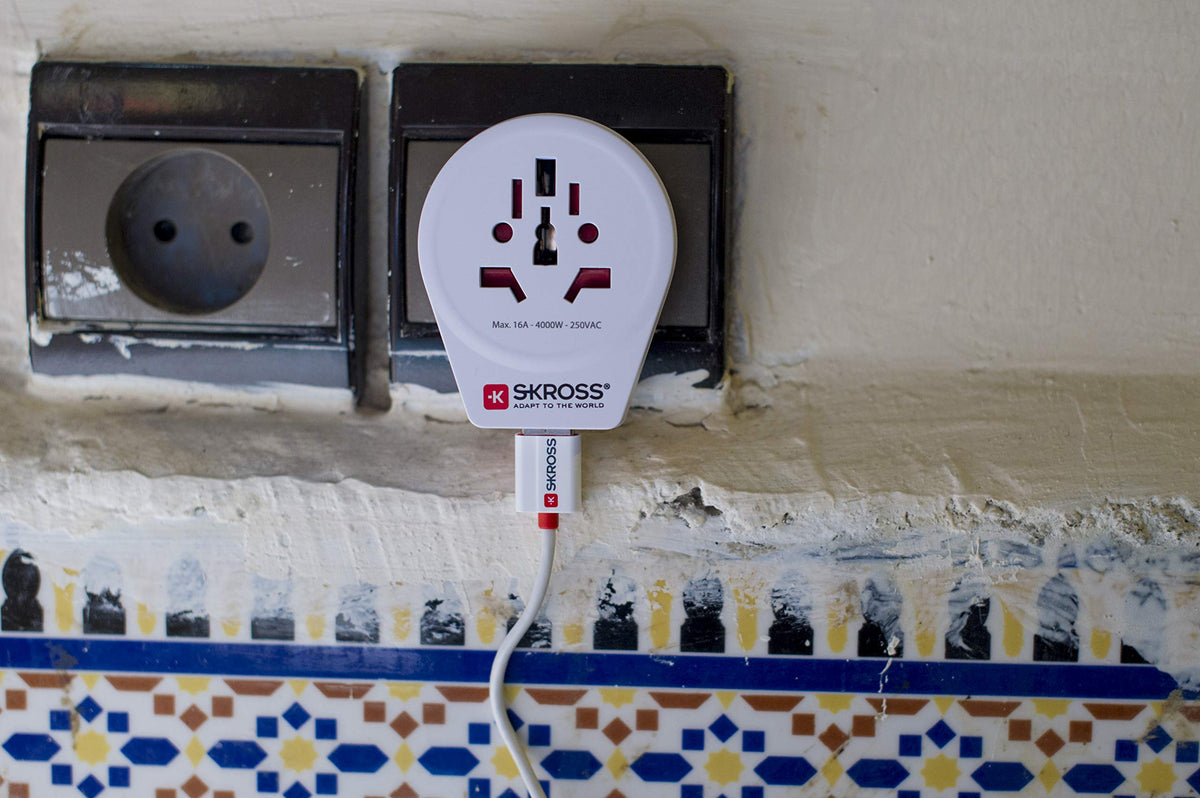 SKROSS white adaptor on a traveler’s desk compact and portable