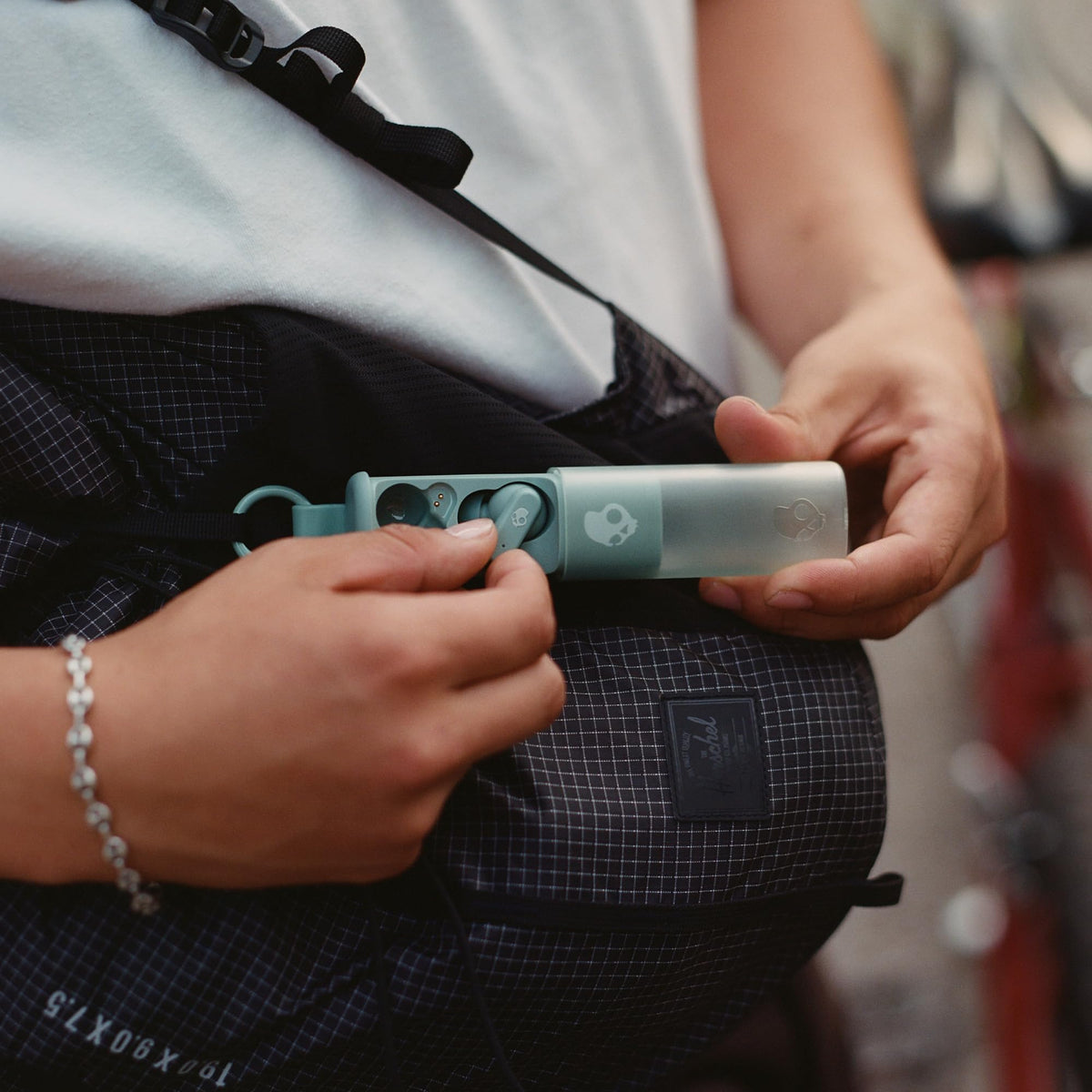 Hand holding Skullcandy Dime Evo earbuds to show ergonomic design and comfort
