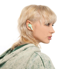Skullcandy Indy Evo beside coin for scale, demonstrates compact portable size