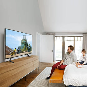 Suptek universal TV stand legs in use on a coffee table for a tidy setup
