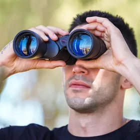 TASCO binoculars held in hand to show size and 27-ounce lightweight portability