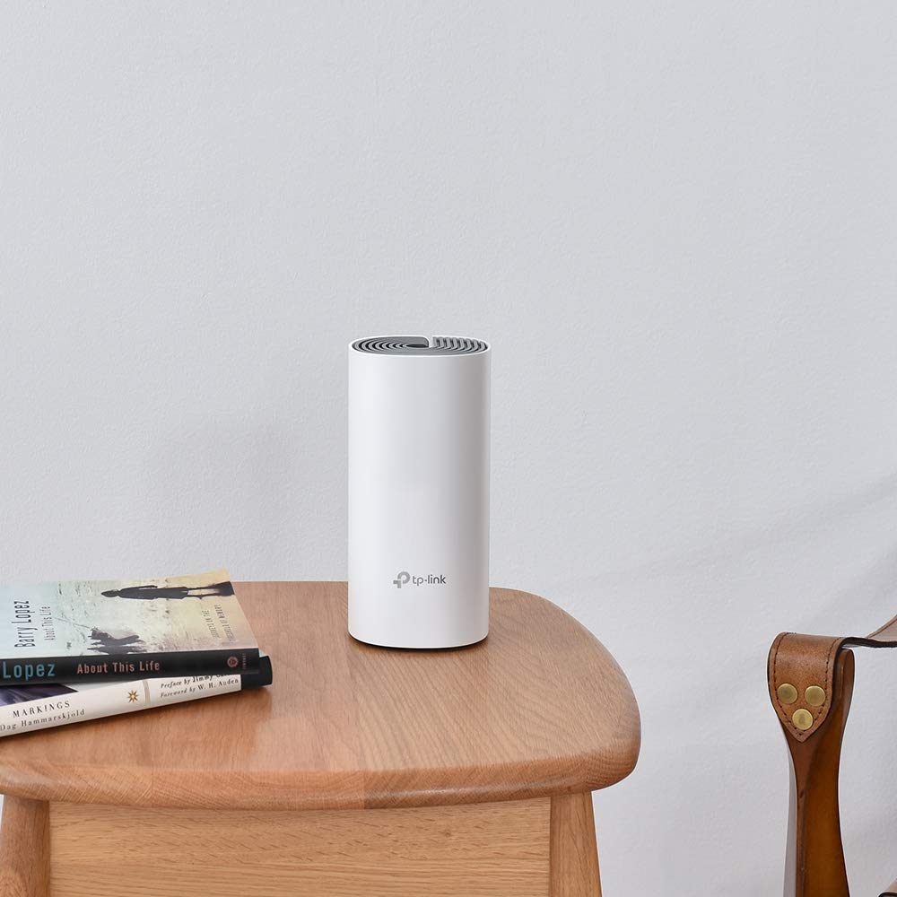TP-Link Deco W2400 next to a smartphone and book showing compact size and space-saving benefit