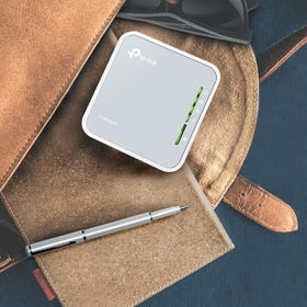 TP-Link TL-WR902AC in a hotel room converting wired Ethernet into private Wi-Fi for secure browsing