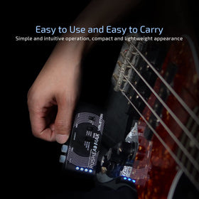 Valeton Rushead Max beside a bass guitar to show pocket-sized scale and travel convenience