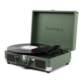 Victrola Journey II green suitcase open, ready for on-the-go listening at a cozy setup.