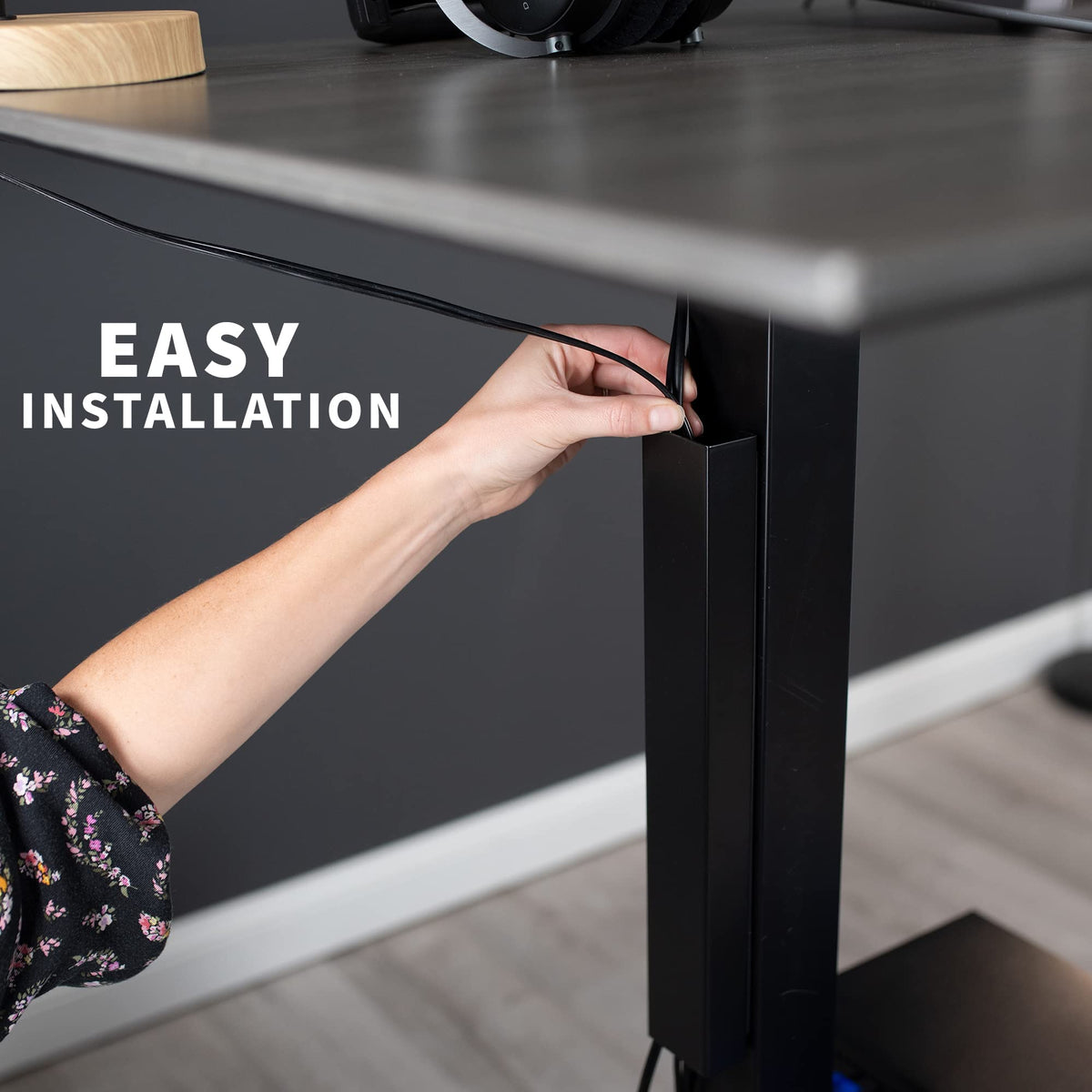 VIVO DESK-AC01-1MB standing-desk use shows safe cord routing during height adjustments.
