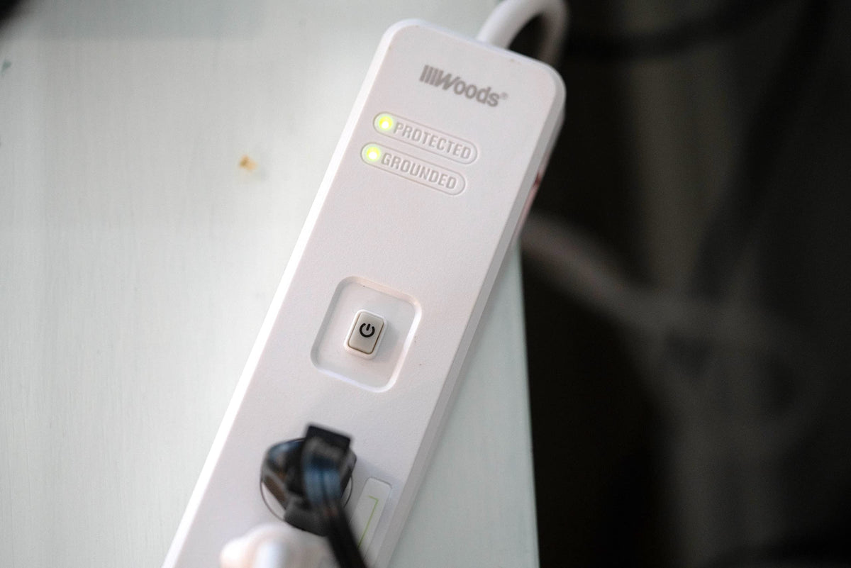 Woods Southwire power strip installed behind TV showing surge protection benefit