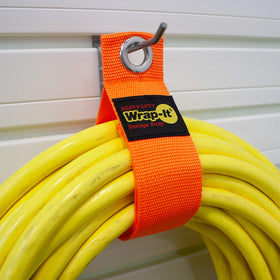 Blaze orange Wrap-It Storage strap organized for garage storage and tool area.