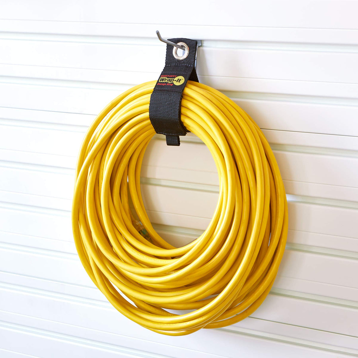 Wrap-It Storage hoses hung on garage pegboard using straps saving floor space benefit