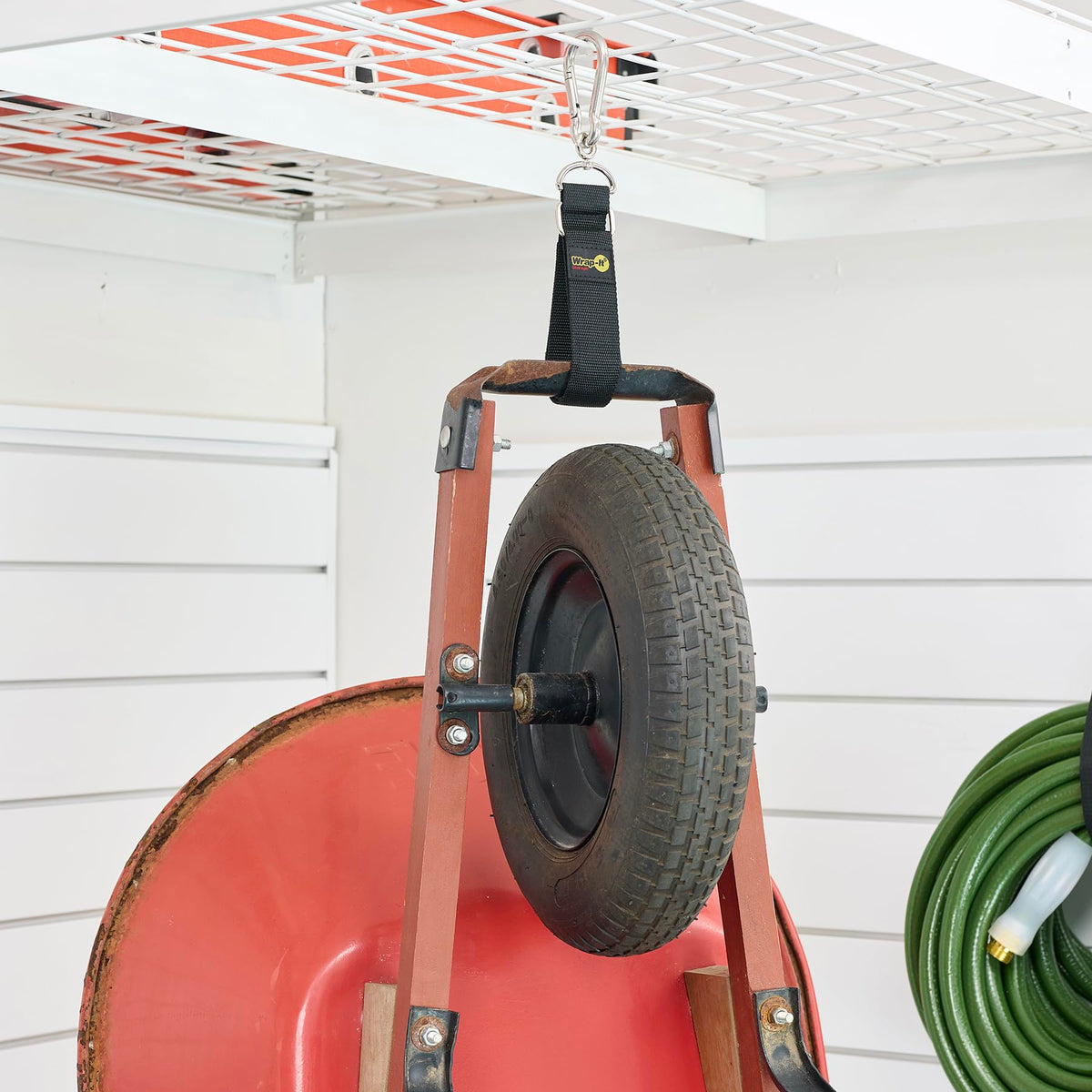 Wrap-It Storage securing a garden hose on a wall hook, preventing kinks and tangles
